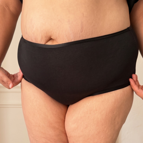 Culotte anti-frottement noire portée sur un ventre tablier